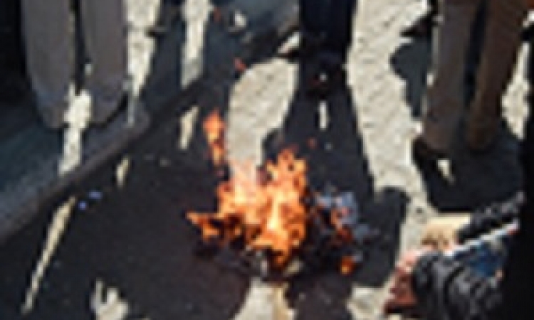 بالصور.. متظاهرون يحرقون جريدة تسب في الداخلية في” عبد المنعم رياض”